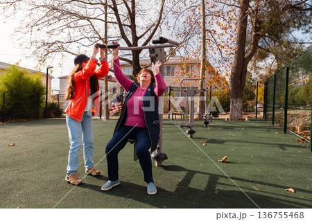 Senior woman following rehabilitation program with outdoor exercise after an operation. Sport supports recovery, vitality, and longevity in retirement. Senior woman following rehabilitation program with outdoor exercise after an operation. Sport supports recovery, vitality, and longevity in retirement. 136755468