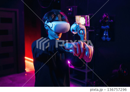 Single player game. Young man is in virtual reality glasses indoors 136757296