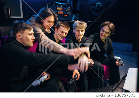 Victory, celebrating. Group of young gamers are indoors Victory, celebrating. Group of young gamers are indoors 136757373