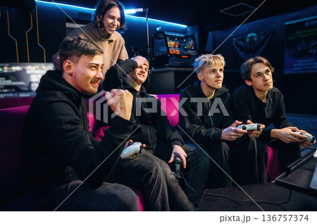 Victory, celebrating. Group of young gamers are indoors Victory, celebrating. Group of young gamers are indoors 136757374