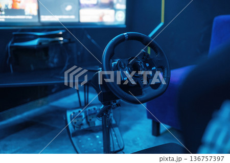 Close up view of driving simulator steering wheel and pedals 136757397