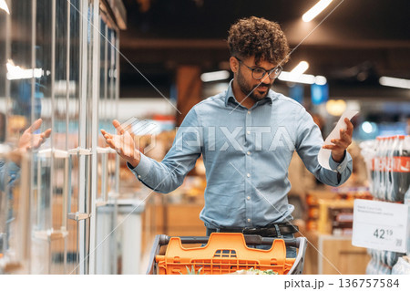 Shopping list in hand. Man is in the grocery store 136757584
