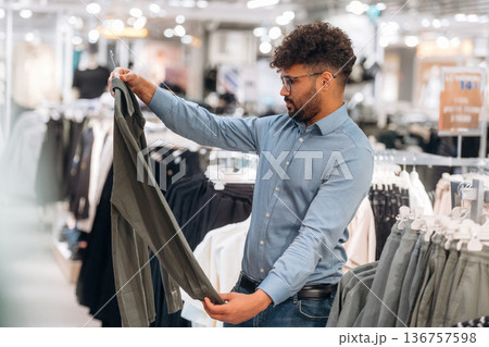 Big choice. Man customer is in the clothing store Big choice. Man customer is in the clothing store 136757598