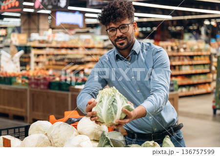 Front view. Man is in the grocery store Front view. Man is in the grocery store 136757599