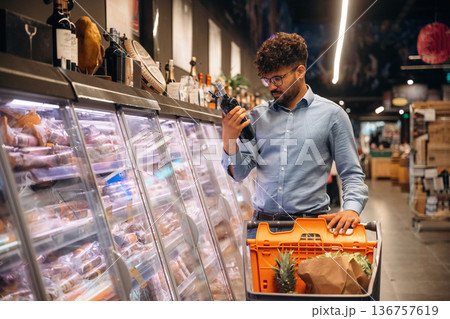 Bottle in hand. Man is in the grocery store Bottle in hand. Man is in the grocery store 136757619