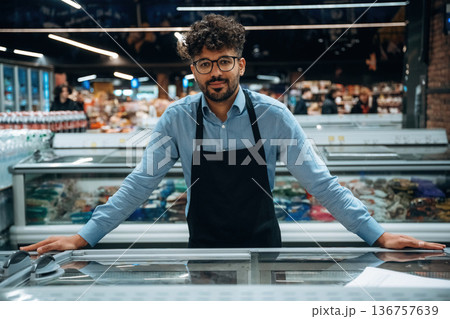 In formal wear. Male worker is in the grocery store In formal wear. Male worker is in the grocery store 136757639