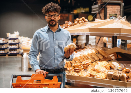 In glasses, choosing products. Man is in the grocery store In glasses, choosing products. Man is in the grocery store 136757643