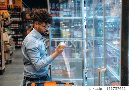 Near fridge with water. Man is in the grocery store Near fridge with water. Man is in the grocery store 136757661