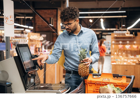 By cash register. Man is in the grocery store 136757666