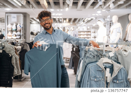 Section with jackets. Man customer is in the clothing store 136757747