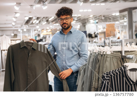 Man customer is in the clothing store Man customer is in the clothing store 136757780
