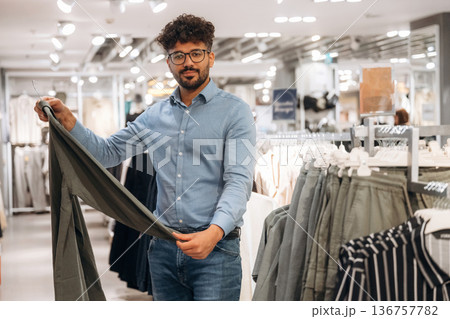 Man customer is in the clothing store Man customer is in the clothing store 136757782