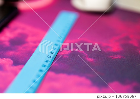 Artistic work environment lit by neon with vivid measuring equipment on patterned fabric 136758067