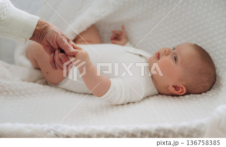 Senior woman is holding hands with little baby 136758385