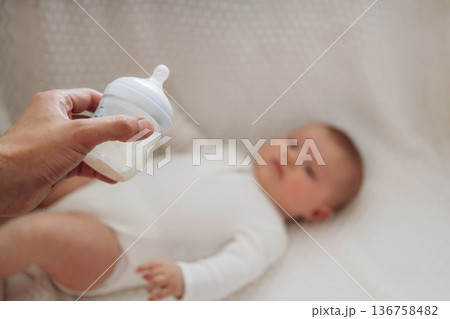 Giving bottle. Close up view of mother and little baby 136758482