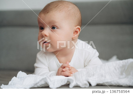 Lying down. Cute little baby is on the sofa Lying down. Cute little baby is on the sofa 136758564