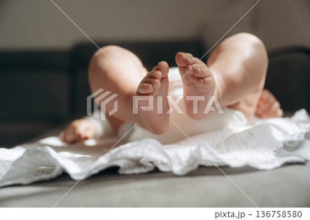 Baby is lying down on the towel, view of the legs 136758580