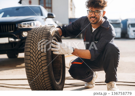 Looking forward, with tire. Mechanic is with the car outdoors 136758779