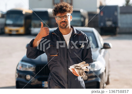 Work is done. Mechanic is with the car outdoors Work is done. Mechanic is with the car outdoors 136758857