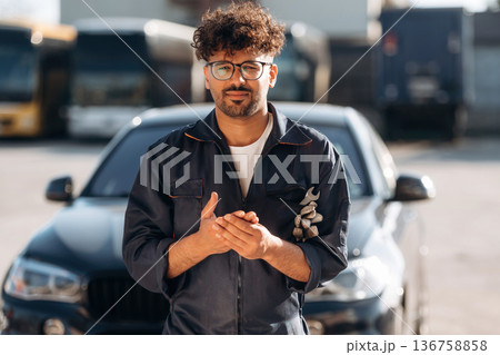 Work is done. Mechanic is with the car outdoors Work is done. Mechanic is with the car outdoors 136758858