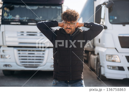 Front view. Male worker is near truck outdoors 136758863