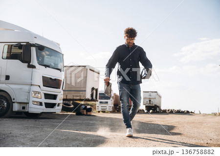 Walking forward. Male worker is near truck outdoors Walking forward. Male worker is near truck outdoors 136758882