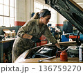 エンジンに向き合う女性メカニック 136759270