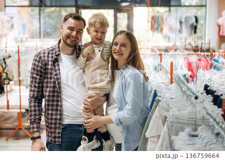 Father, son and pregnant mother are in kid's clothing store Father, son and pregnant mother are in kid's clothing store 136759664