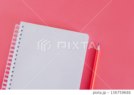 Notebook with a blank page and a pencil on pink background. 136759688