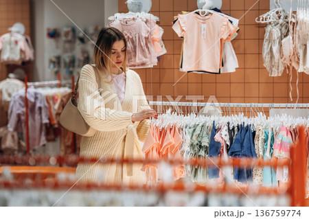 Woman is choosing wear in the kid's clothing store 136759774