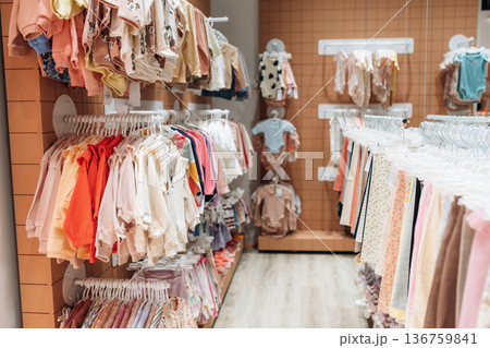 Inside the kid's clothing store. Shirts and sweaters are hanging Inside the kid's clothing store. Shirts and sweaters are hanging 136759841