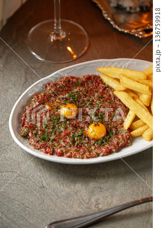 Beef tartare with egg yolk and french fries 136759918