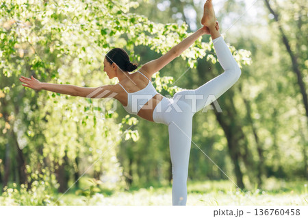 Practicing the asana. Beautiful fitness yoga woman is outdoors, amazing nature Practicing the asana. Beautiful fitness yoga woman is outdoors, amazing nature 136760458