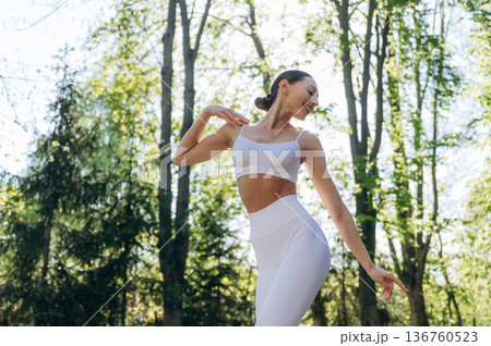 Standing in the forest. Beautiful fitness yoga woman is outdoors, amazing nature Standing in the forest. Beautiful fitness yoga woman is outdoors, amazing nature 136760523