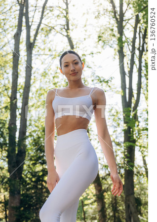 Standing in the forest. Beautiful fitness yoga woman is outdoors, amazing nature Standing in the forest. Beautiful fitness yoga woman is outdoors, amazing nature 136760524