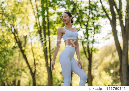 Against trees, standing. Beautiful fitness yoga woman is outdoors, amazing nature Against trees, standing. Beautiful fitness yoga woman is outdoors, amazing nature 136760543