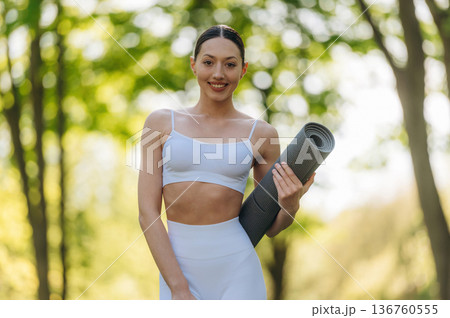 In fitness clothes. Beautiful yoga woman is outdoors, amazing nature In fitness clothes. Beautiful yoga woman is outdoors, amazing nature 136760555