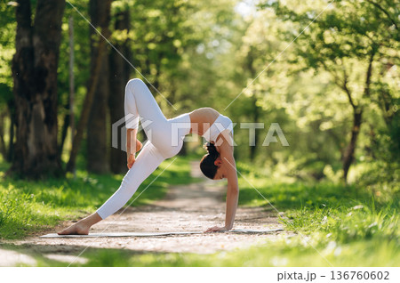 Sportive activity, doing exercise. Beautiful fitness yoga woman is outdoors, amazing nature Sportive activity, doing exercise. Beautiful fitness yoga woman is outdoors, amazing nature 136760602