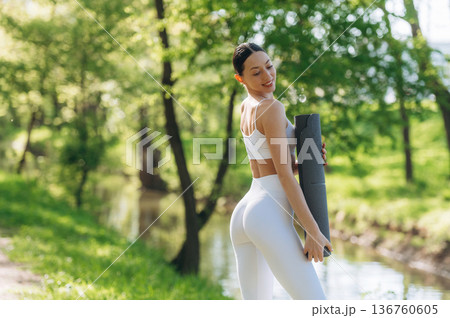 Near the river. Beautiful fitness yoga woman is outdoors, amazing nature 136760605