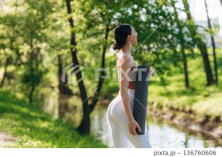 Near the river. Beautiful fitness yoga woman is outdoors, amazing nature 136760606