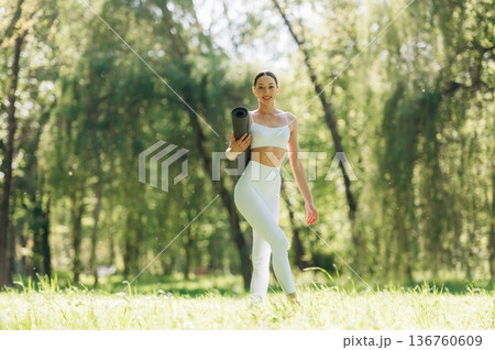 Smiling, positive facial expression. Beautiful fitness yoga woman is outdoors, amazing nature Smiling, positive facial expression. Beautiful fitness yoga woman is outdoors, amazing nature 136760609