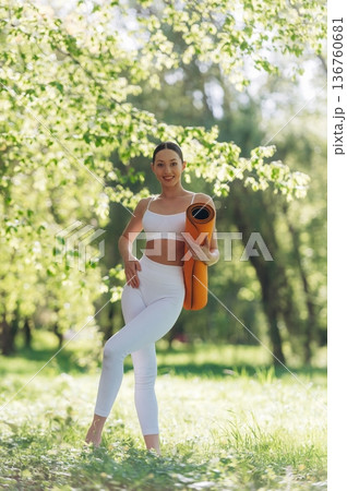 Enjoying nature, standing. Beautiful fitness yoga woman is outdoors, amazing nature Enjoying nature, standing. Beautiful fitness yoga woman is outdoors, amazing nature 136760681