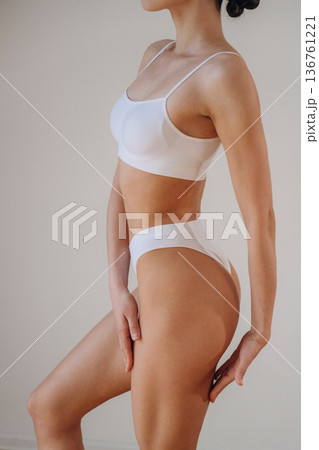 Woman is standing and posing. Close up view of sportive person that is in fitness clothes Woman is standing and posing. Close up view of sportive person that is in fitness clothes 136761221