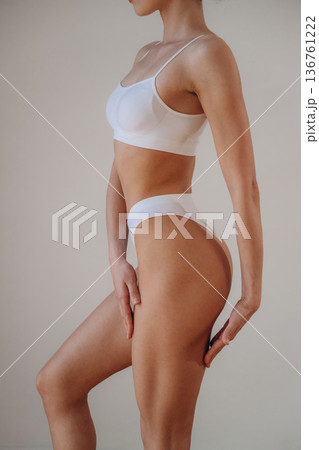 Woman is standing and posing. Close up view of sportive person that is in fitness clothes 136761222