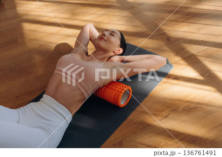 Top view. Woman is doing abs on the yoga mat at home Top view. Woman is doing abs on the yoga mat at home 136761491