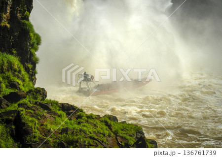 Boat zodiac taking tourist under the Iguazu falls waterfalls Scenic destination in Argentia Boat zodiac taking tourist under the Iguazu falls waterfalls Scenic destination in Argentia 136761739