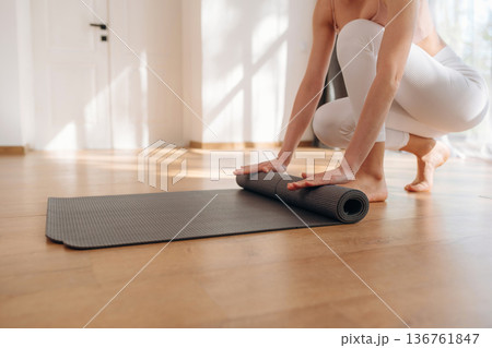 Preparing, with mat. Yoga time, close up view of woman that is practicing at home Preparing, with mat. Yoga time, close up view of woman that is practicing at home 136761847