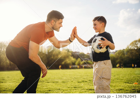 Giving high five. Father and son are having fun outdoors 136762045
