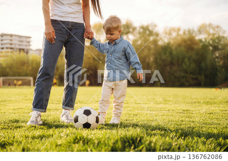Warm sunlight. Mother and son are together on the summer field Warm sunlight. Mother and son are together on the summer field 136762086