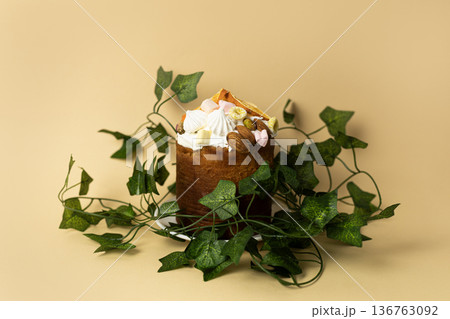 Easter cake adorned with fresh green leaves on light peach background, elegant spring holiday presentation Easter cake adorned with fresh green leaves on light peach background, elegant spring holiday presentation 136763092